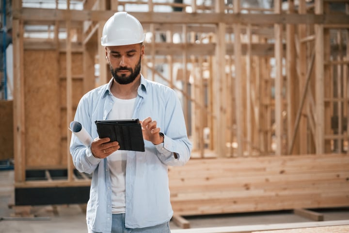 man on tablet on job site